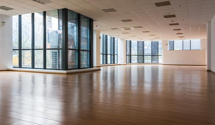 Spacious commercial office interior with clean polished laminate wood flooring