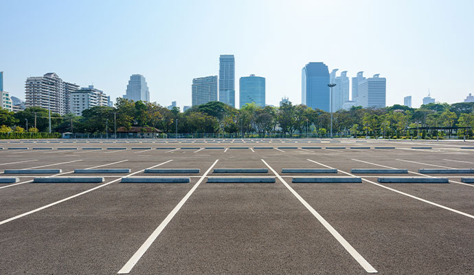 Empty commercial parking lot with a clear view of a modern city skyline