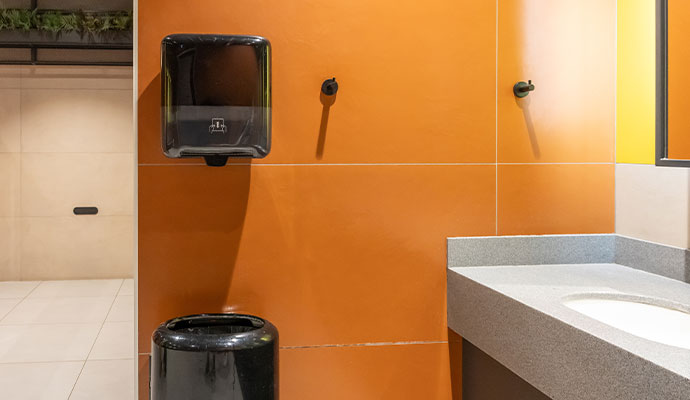 Commercial restroom with wall-mounted paper towel dispenser and vanity counter