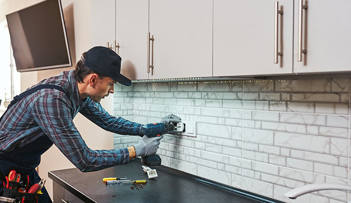 Electrician installing socket on the wall