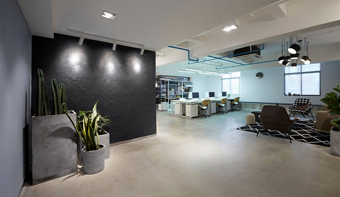 The interior of a contemporary office with minimalist furniture, light fixtures, and an open layout
