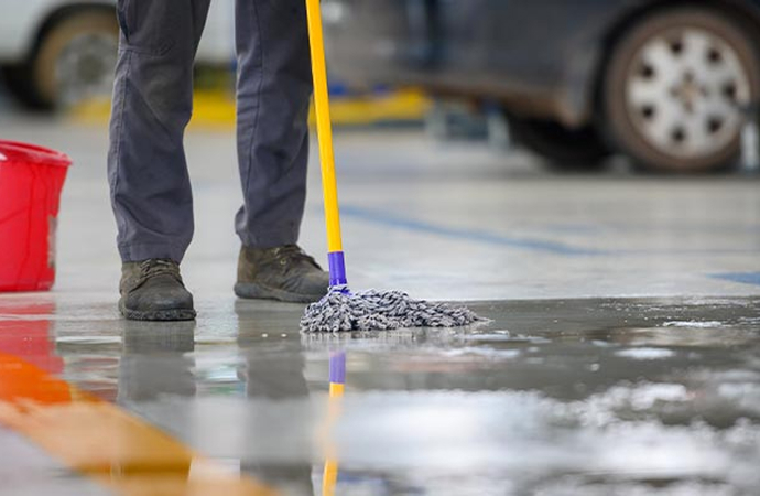 An expert mopping a concrete garage floor