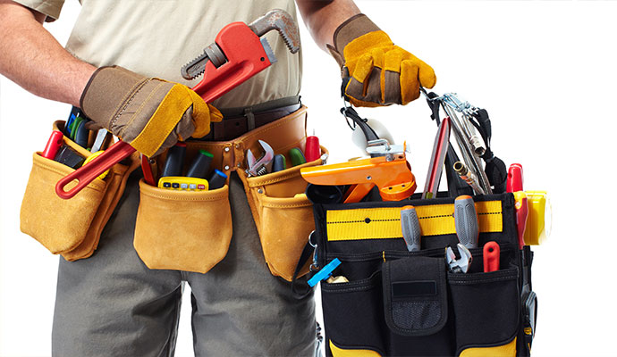 A close-up shot of a contractor with a fully loaded tool belt and bag