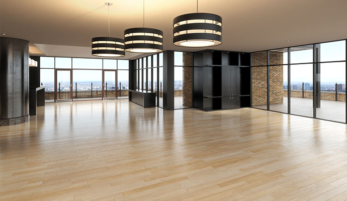 The interior of a contemporary penthouse with light wood floors, large glass doors leading to a terrace, and a brick accent wall