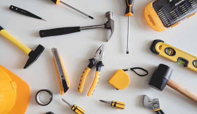 A collection of common household and construction tools scattered on a tabletop
