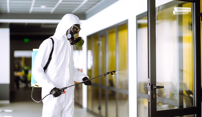 Professional disinfecting an office interior using spray equipment