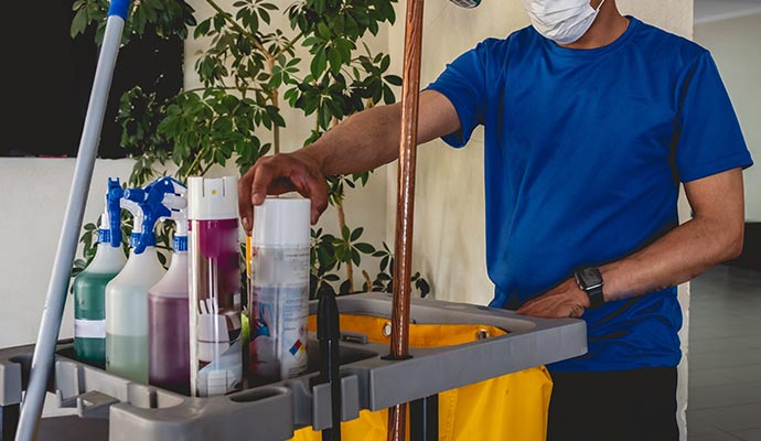 Essential office cleaning equipment including mop, disinfectant bottles, and waste bag