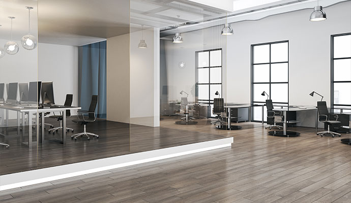 The interior of a modern, minimalist office with multiple workstations and a large open space