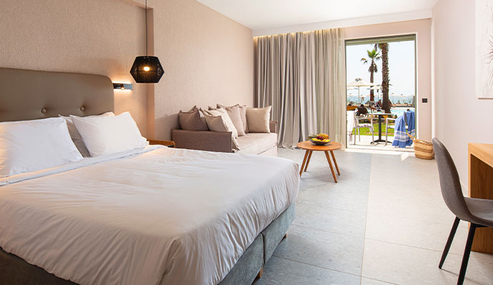The interior of a luxury hotel room with a clean, minimalist design and a large window or glass door