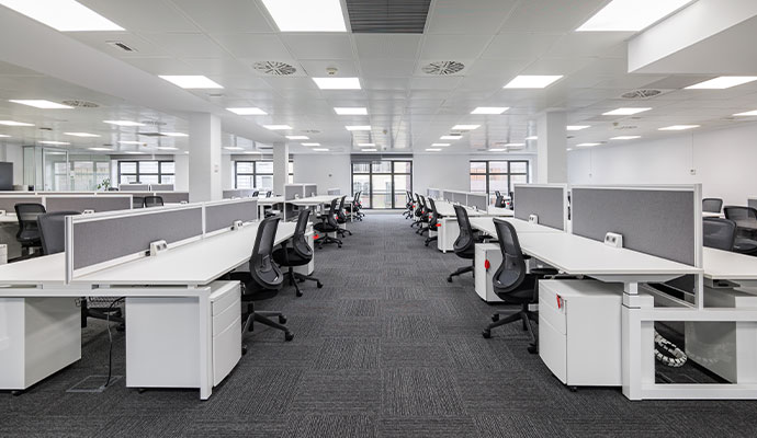 An empty corporate office with a clean floor and well-organized cubicles, ready for employees to use