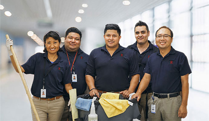 Professional commercial cleaning crew with service cart in commercial building